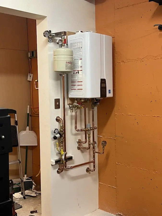 Plumbing technician inspecting water heater connections in Parsons